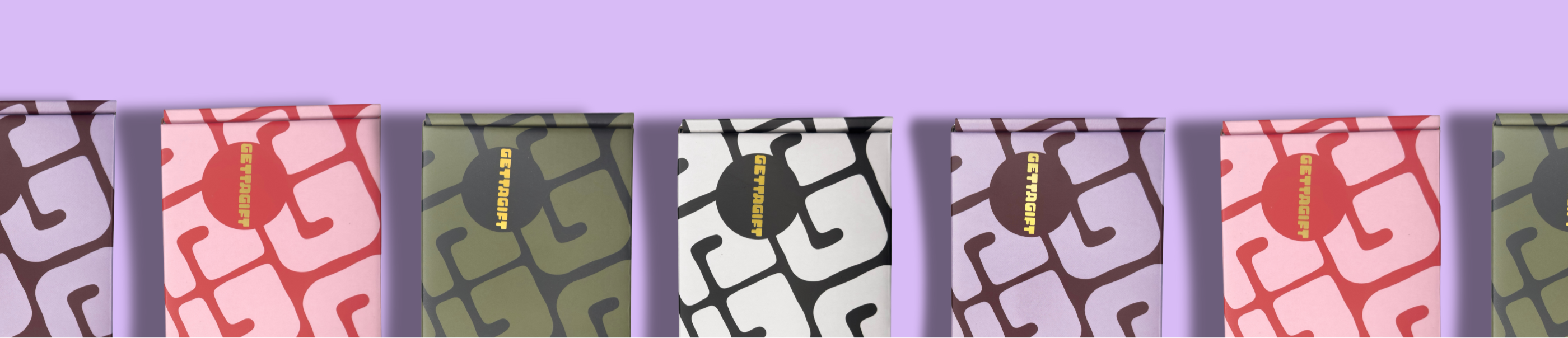 Row of gift boxes with colorful covers on a purple background