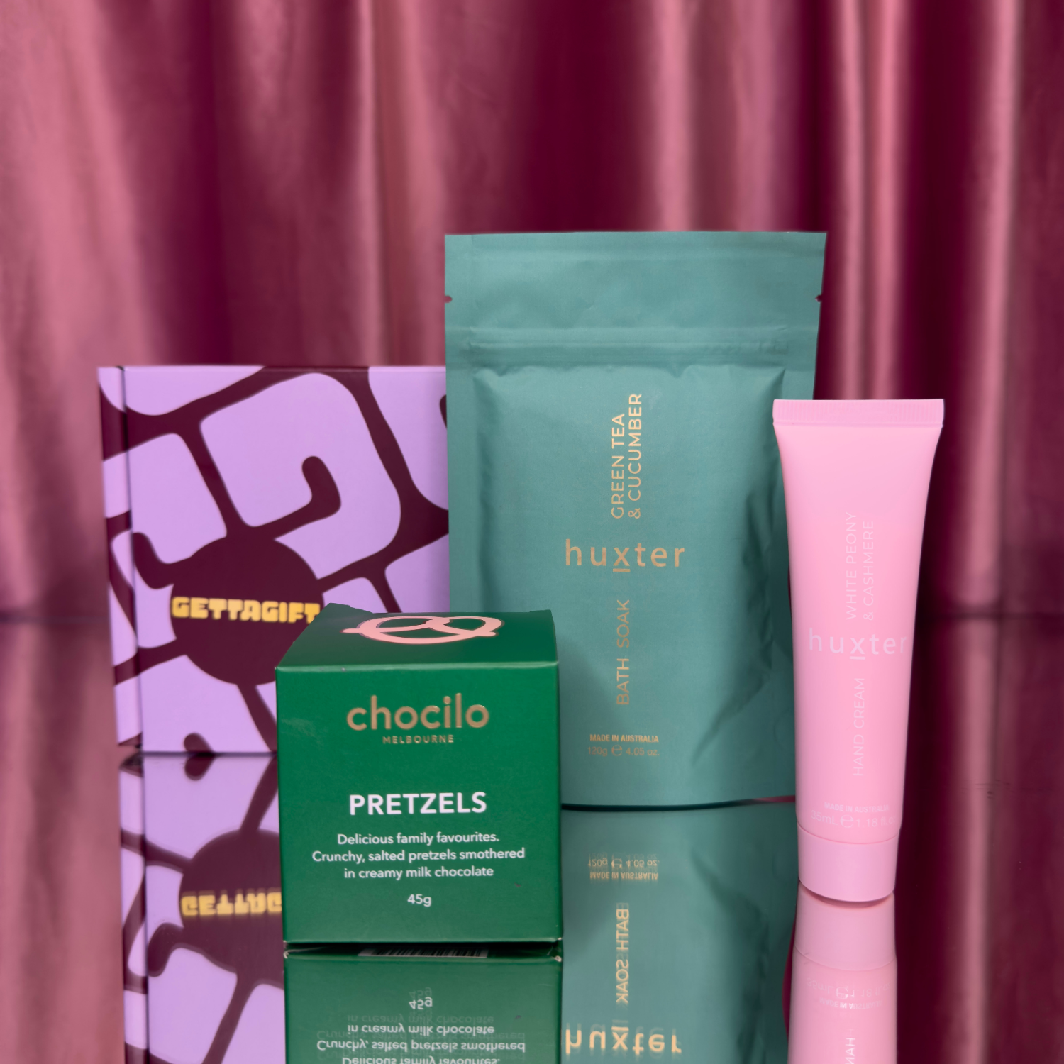 GettaGift Soak and Snack box featuring Chocilo Melbourne chocolate pretzels, Huxter green tea and cucumber bath soak, and Huxter white peony and cashmere hand cream a luxe, feel-good gift box with sweet treats and pampering essentials.